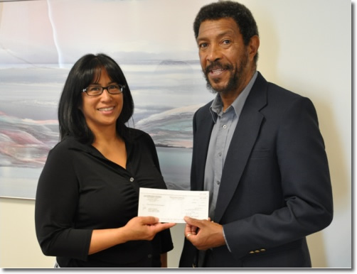 Photo of Dr. Lawford Goddard  receiving his settlement check from EEOC Attorney Linda Ordonio-Dixon